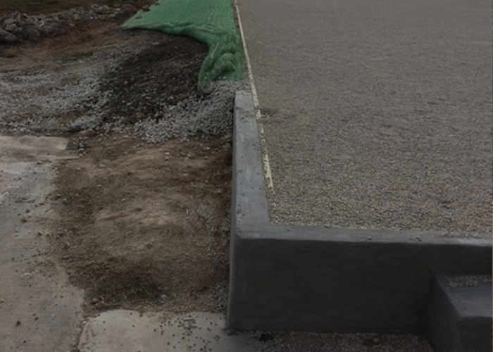 Section of a gravel driveway next to a concrete border