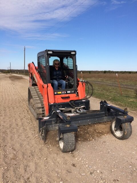IMG_6345 An orange skid steer with a grader attachment